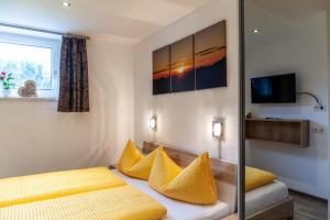 a bedroom with two beds with yellow pillows at Haus Alpenheim Apartment 2 in Tux