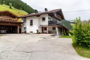 a large white house with a parking lot at Haus Alpenheim Apartment 2 in Tux