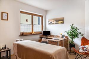 a room with a bed and a desk and a tv at Studio Hochzillertal mit Sauna in Ried im Zillertal