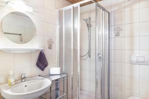 a white bathroom with a shower and a sink at Studio Hochzillertal mit Sauna in Ried im Zillertal