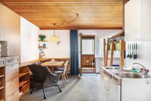 a kitchen with a wooden ceiling and a table with chairs at Studio Hochzillertal mit Sauna in Ried im Zillertal +29 photos
