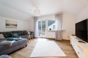 a living room with a couch and a tv at Sonnenterrasse 9 in Fischerbach
