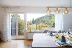 a kitchen with a table and a large window at Sonnenterrasse 9 in Fischerbach