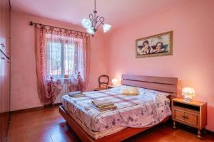 a bedroom with pink walls and a bed and a window at Casa Gaia in Prataccio