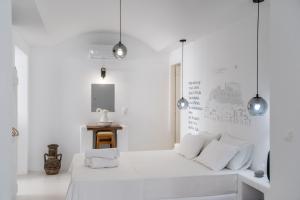 a white room with a white bed and pendant lights at Helmos Cozy Studio in Naxos Chora