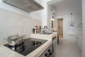 a kitchen with a stove with a pot on a counter at Helmos Cozy Studio in Naxos Chora +12 photos
