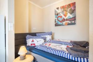a bedroom with a bed with striped pillows on it at Ferienwohnung Ausblick in Bremerhaven