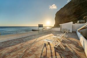 a group of chairs sitting on a balcony overlooking the ocean at Apartamentos Playa Azul - 2 in Vallehermoso