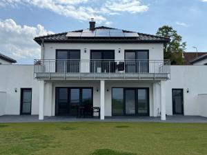 a white house with a balcony on top of it at Berg und Meer in WÃ¶lpinghausen