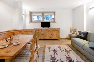 a living room with a wooden table and a couch at Chalet Pieri - Appartamento Temelin in Bormio
