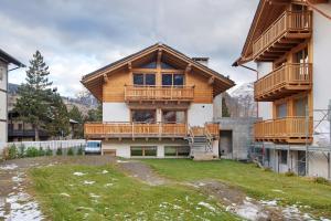 a large house with a balcony and a yard at Chalet Pieri - Appartamento Temelin in Bormio