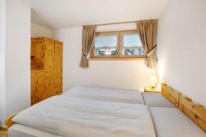a bedroom with a bed and a window at Chalet Pieri - Appartamento Temelin in Bormio