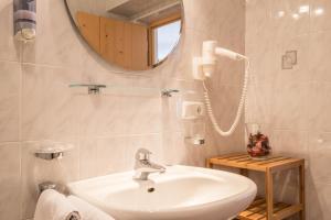 a bathroom with a sink and a mirror at Apartment Enzian - Mesnerhof in Sand in Taufers +15 photos