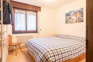 a small bedroom with a bed and a window at Casa Muffolina in Canazei