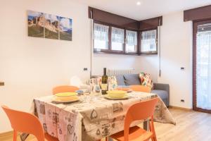 a dining room with a table with chairs and a couch at Casa Muffolina in Canazei