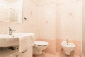 a bathroom with a sink and a toilet and a mirror at Casa Muffolina in Canazei +17 photos