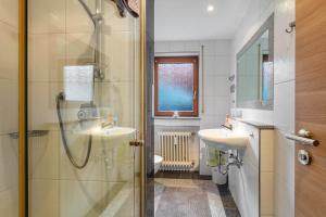 a bathroom with two sinks and a shower at Ferienwohnung Sägegasse, Typ A in Münstertal +16 photos