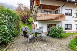 a patio with a table and chairs in front of a house at Ferienwohnung Sägegasse, Typ A in Münstertal