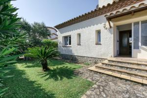 a house with a small palm tree in the yard at Flores in Vilacolum