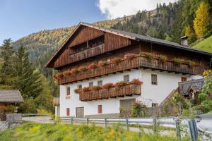 a building with flowers on the balconies of it at Oberhof Bauernhaus in Vallarga