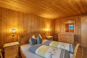 a bedroom with a bed and a wooden wall at Oberhof Bauernhaus in Vallarga