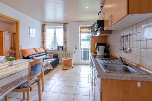 a kitchen with a sink and a living room at Heizmannshof in Hofstetten
