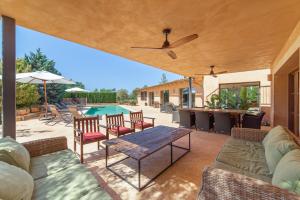 a patio with a table and chairs and a pool at S'hort des Frares in El Palmer
