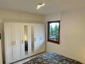 a bedroom with white cabinets and a window at Haus Balke in Hatzfeld