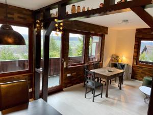 a dining room with a table and some windows at Haus Balke in Hatzfeld
