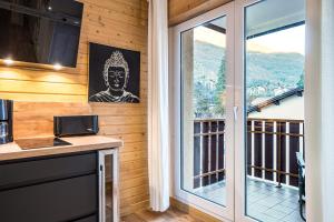 a kitchen with a balcony with a large window at Studio Bee Happy in Brides-les-Bains