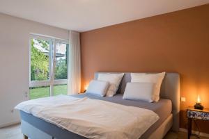 a bedroom with a bed with two pillows and a window at Ferienwohnung Tödiblick in Wangen im Allgäu