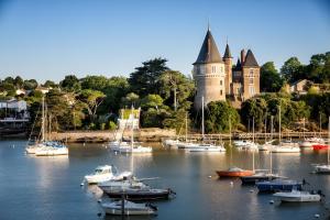 a bunch of boats in the water in front of a castle at Aux Pins Maritimes - A22 in Pornic