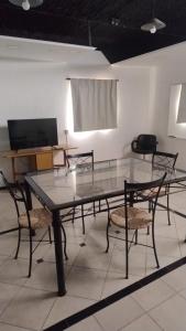 a glass table and chairs in a room at Alojamiento El Centenario in San Martín
