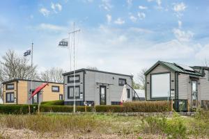 a house with two flags in front of it at Tiny House Ingo John 'Vanessa' in Sandstedt