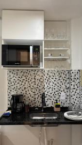 a kitchen with a sink and a microwave at Lindo Flat Completo 311 in Nova Iguaçu