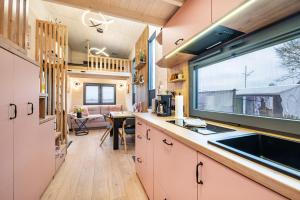 a kitchen with a sink and a window at Tiny House Ingo John 'Vanessa' in Sandstedt +21 photos