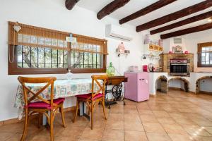 a kitchen with a table with chairs and a pink refrigerator at Can Wancho in Botarell