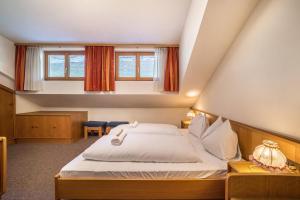 a bedroom with a large bed and two windows at Manuel's App Watschinger - Frieda in Sesto