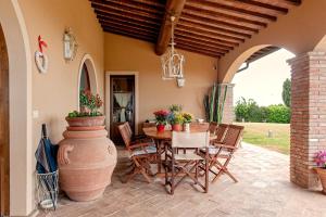 a patio with a table and chairs and a vase at Villa delle Palme in Cecina