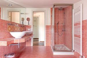 a bathroom with a sink and a shower with red tiles at Villa delle Palme in Cecina +35 photos
