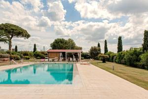 a swimming pool with a gazebo in a park at Villa delle Palme in Cecina