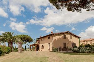 a house with a palm tree and a yard at Villa delle Palme in Cecina