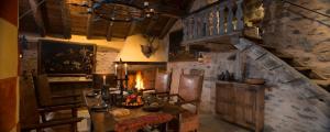 comedor con mesa, sillas y pared de piedra en Confrérie du Moyen Âge en Verrayes