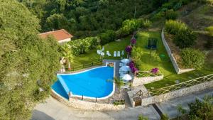 an aerial view of a swimming pool in a garden at Arcaloro Resort in SantʼAngelo di Brolo