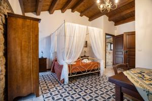a bedroom with a canopy bed and a table at Arcaloro Resort in SantʼAngelo di Brolo