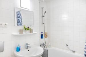a white bathroom with a sink and a tub at Nahe Airport Ber Maisonettewohnung in Schönefeld +12 photos