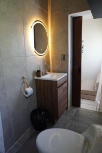 a bathroom with a white sink and a mirror at Departamento zona central in La Paz +14 photos