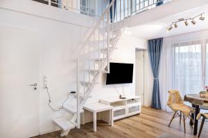 a white staircase in a living room with a table at Nahe Airport Ber Maisonettewohnung in Schönefeld