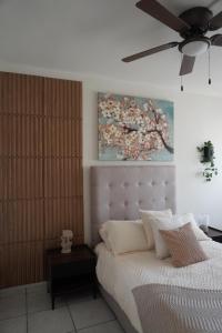 a bedroom with a white bed with a ceiling fan at Departamento zona central in La Paz
