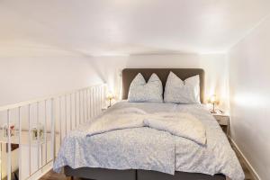 a white bedroom with a bed with blue pillows at Nahe Airport Ber Maisonettewohnung in Schönefeld